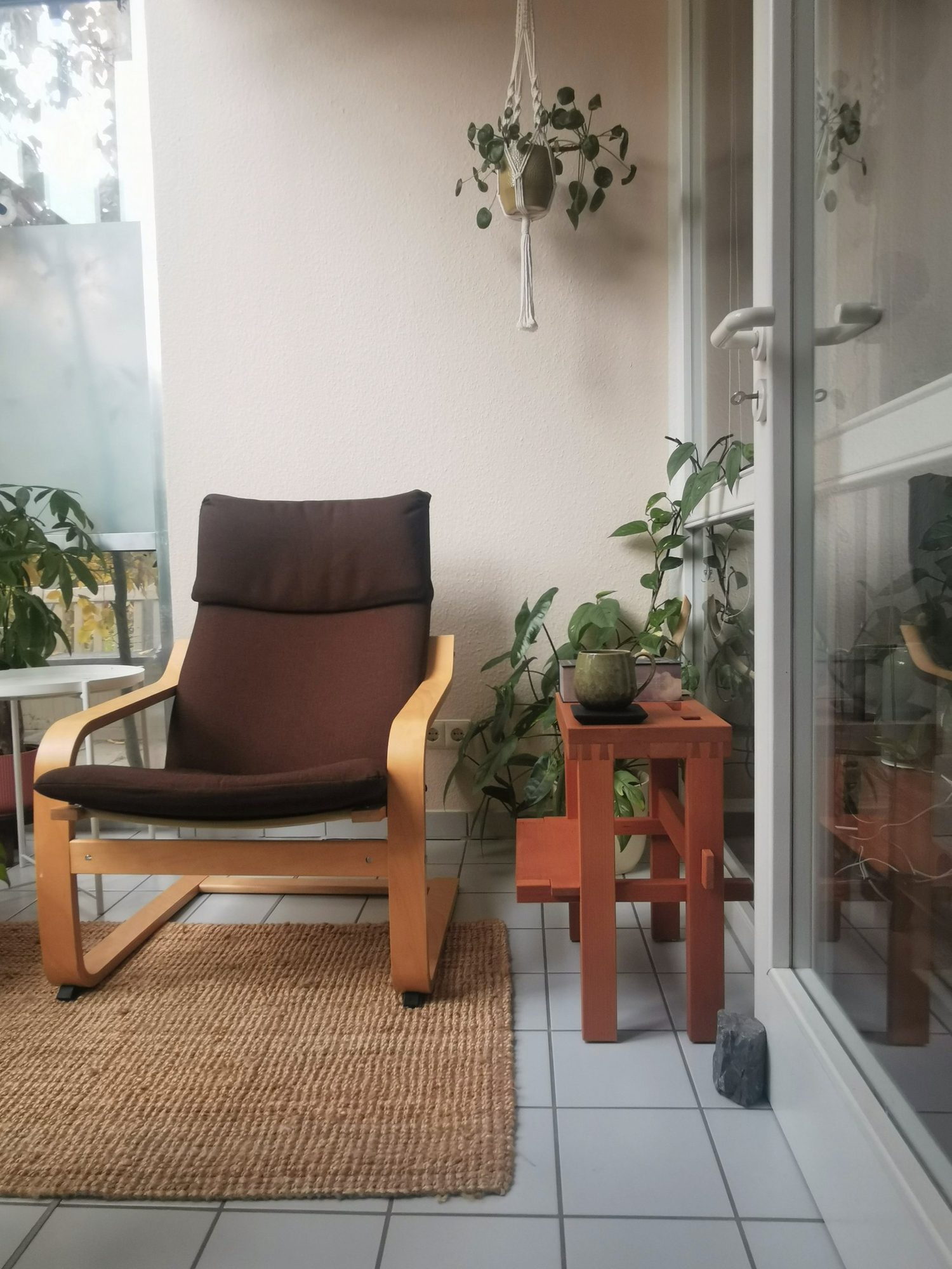 Der Hocker als Beistelltisch in der Leseecke neben einem Sessel
