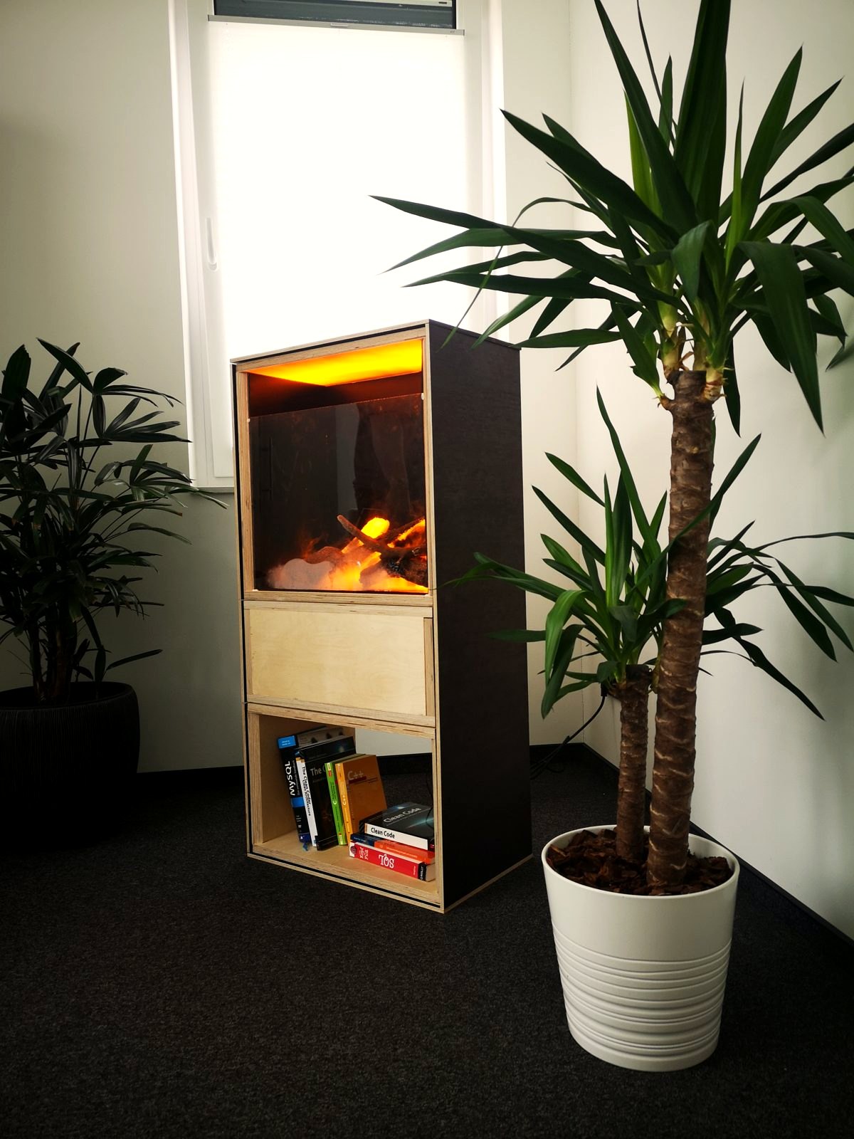 Prototyp mit Licht und Flamme, unten Bücher im Regal