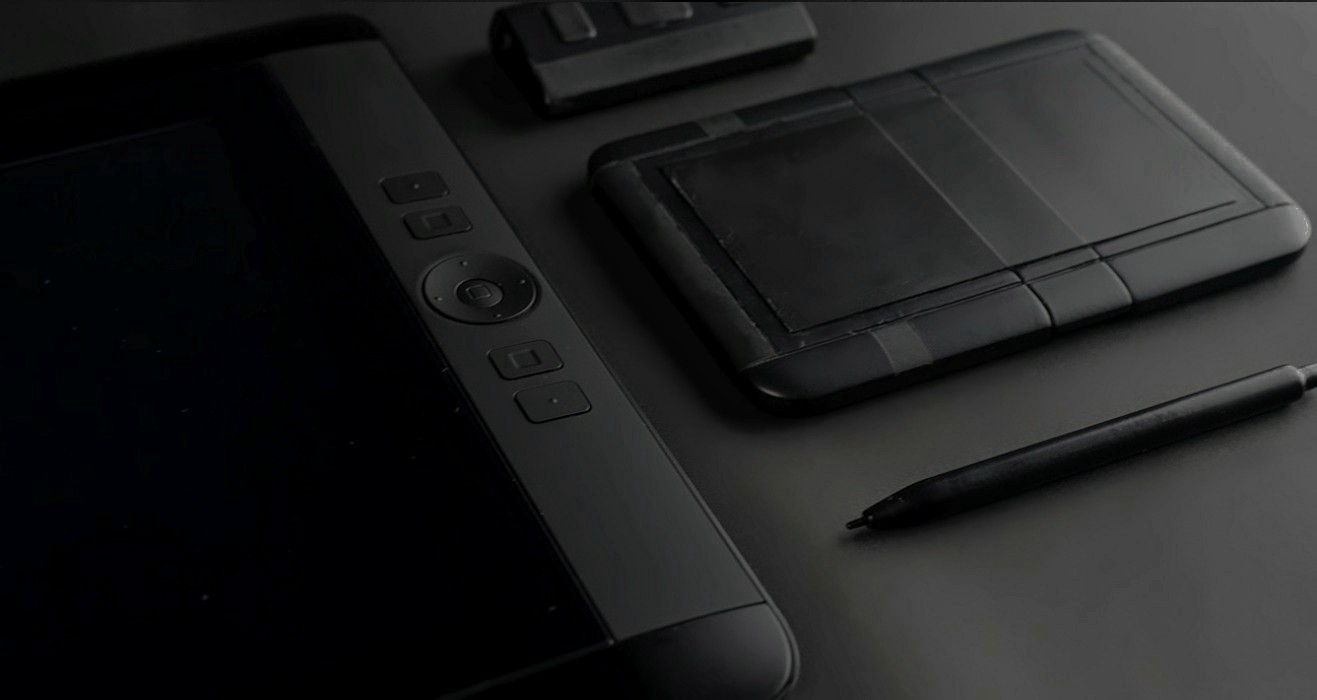 Wacom Hybrid neben einem Wacom-Grafiktablett, mit Stift, auf dunklem Grund