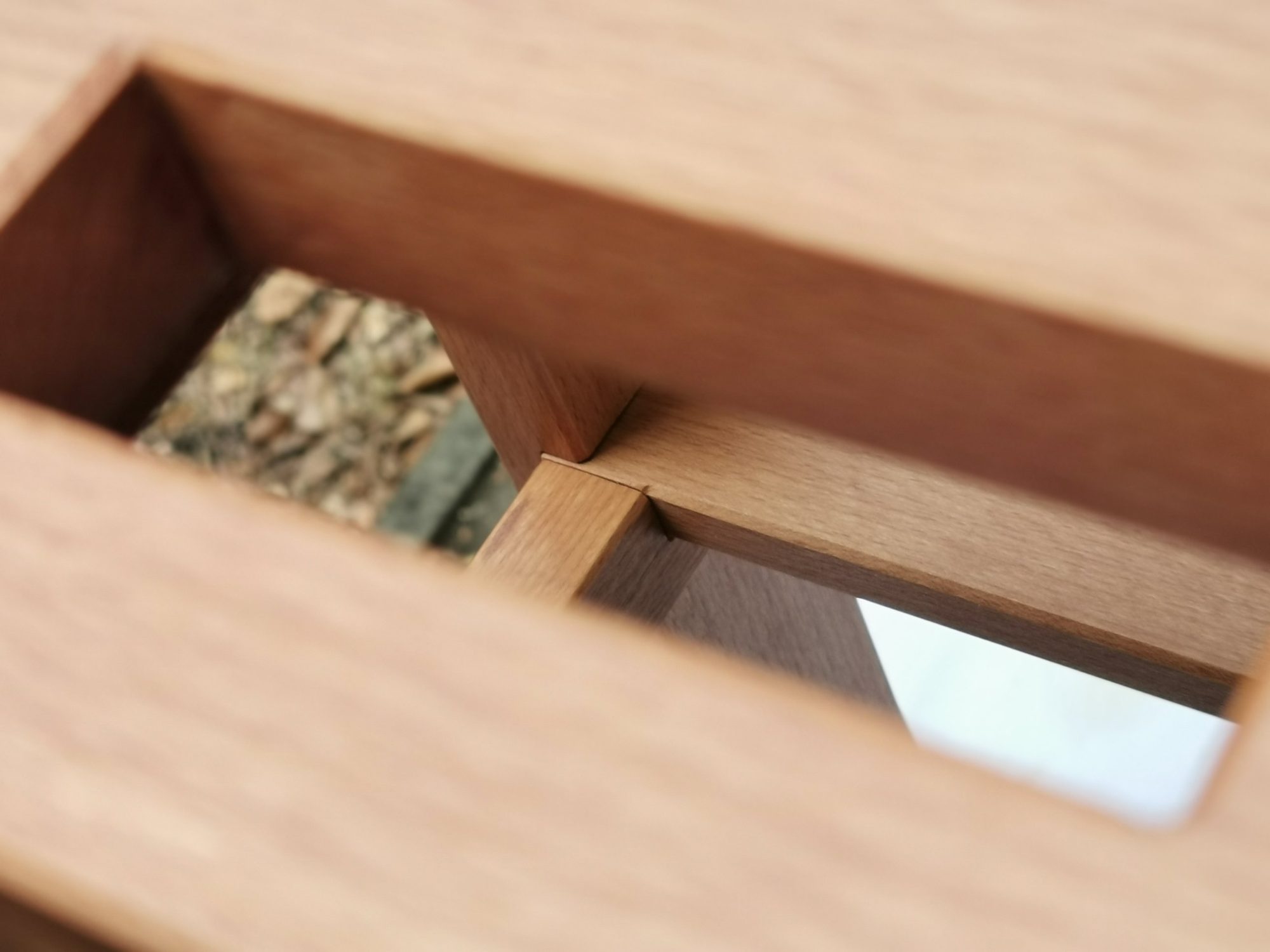 Blick durch einen Durchbruch der Sitzfläche auf Gestell und Tritt